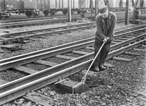 834486 Afbeelding van een wegwerker van de N.S. tijdens onderhoudswerkzaamheden aan het spoor te Gouda.